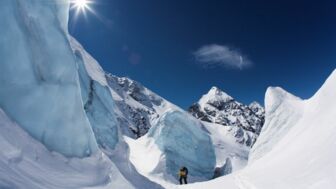 Skitourengeher im Aufstieg zwischen blauem Gletschereis