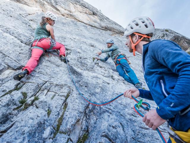 Kletterer gesichert an der Felswand in den Dolomiten