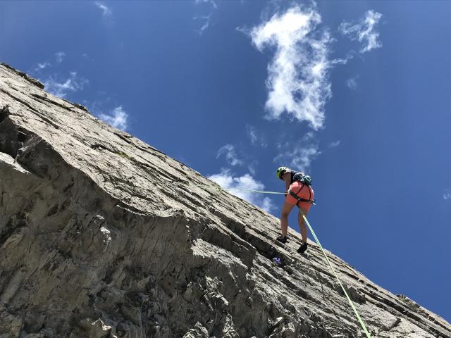 Kletterer beim Abseilen an der Felswand
