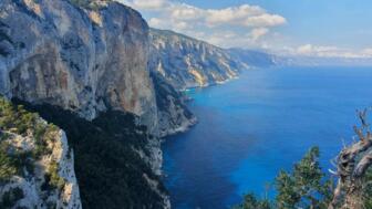 Luftaufnahme von einem felsigen Berg in Richtung schönem blauem Meer