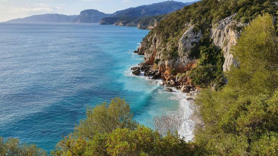 Luftaufnahme von einem felsigen Berg in Richtung schönem blauem Meer