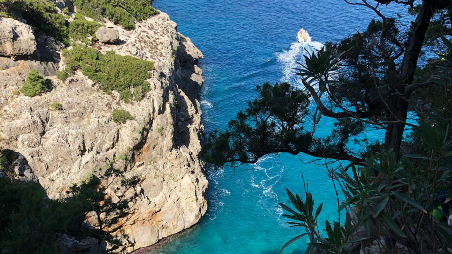 Luftblick auf die steilen Klippen am Meer mit einem Boot im Meer