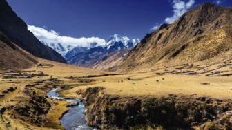 Bergbach und weidende Pferde in der Cordillera Huayhuash vor weißen Bergen