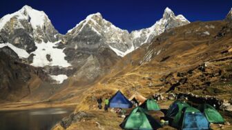 Zeltlager an einem Bergsee in der Corfdillerra Huayhuash mit eindrucksvoller Bergszenerie im Hintergrund