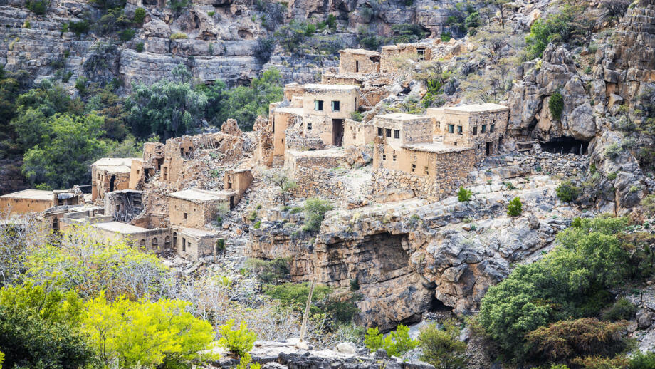 Wadi Bani Habib mit Häusern und Büschen im felsigen Gebirge