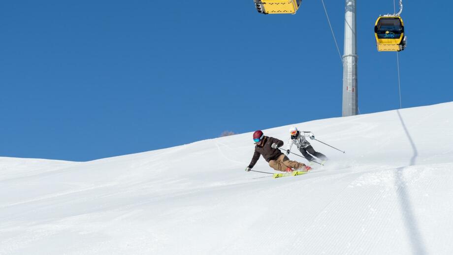 Skifahrer fahren unter dem Lift ab
