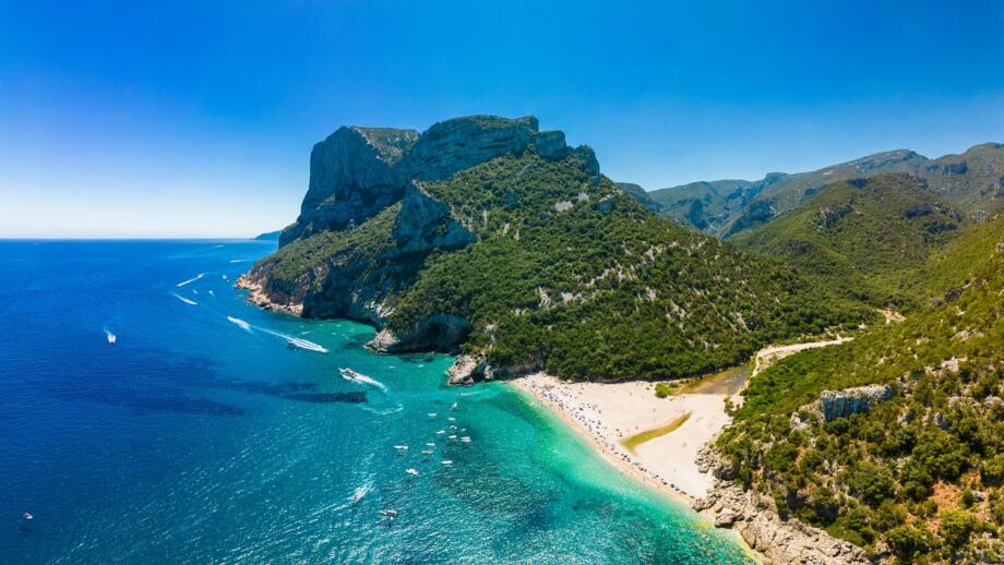 Panorama Blick auf den Strand von Cala Sisine im Golf von Orosei, grüne Landschaft mit Bergen und das türkis blaue Meer