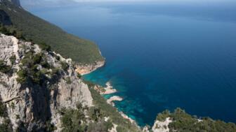 Luftaufnahme von einem felsigen Berg in Richtung schönem blauem Meer