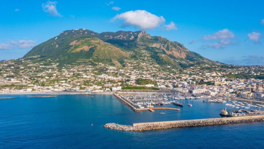 Der Berg Monte Epomeo über der italienischen Stadt Forio am Hafen auf der Insel Ischia