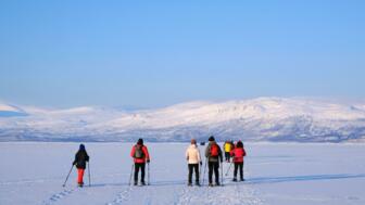 schweden-scwin-silhouetten-von-touristen-auf-schneeschuhen-auf-dem-tornetraesk-see-um-den-abisko-nationalpark-shutterstock_2272682537.jpg