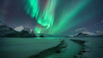 norwegen-lofoten-nolos-nordlichter-schneebedeckte-berge-sandstrand-bach-bei-sternigem-winterabend-shutterstock_2413914289.jpg