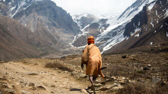 nepal-hivieve-nepalese-man-walking-on-a-mountain-road-shutterstock_1630960171.jpg