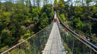 nepla-hikat-trekking-enthusiasten-ueberqueren-eine-haengebruecke-auf-balthali-village-trek-kathmandu-valley-shutterstock_2444372853.jpg