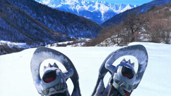 Aufnahme von Schneeschuhen mit dem Kaukasus Gebirge im Hintergrund
