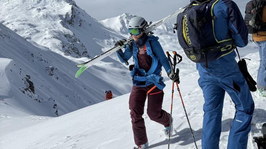 Freeriderin mit Ski auf den Schultern