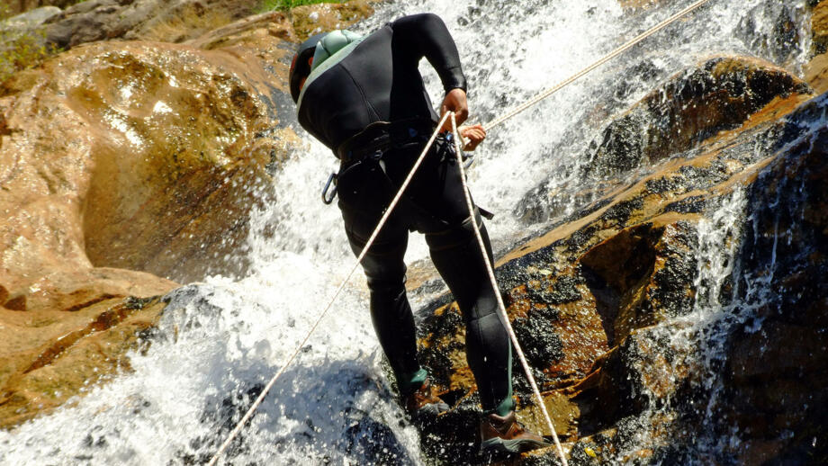 Wanderer beim Canyoning angeseilt am Wasserfall