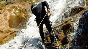 Wanderer beim Canyoning angeseilt am Wasserfall