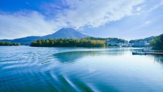Akan-See auf der Insel Hokkaido mit Wasser, Bäumen und Vulkanberg im Hintergrund
