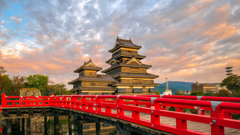 Pagodenähnliche Krähenburg bei Matsumoto mit roter Brücke im vordergrund