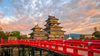 Pagodenähnliche Krähenburg bei Matsumoto mit roter Brücke im vordergrund