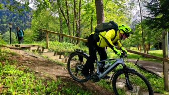 Ein E-Mountainbiker während des Fahrtechniktrainings im Kleinwalsertal bei der Übung der Grundposition auf dem Mountainbike.