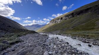 Blick in ein Tal mit einem kleinen Fluss im Tarfala Tal