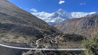 Ein Mountainbiker fährt über eine Brücke bei der Annapurna-Umrundung.