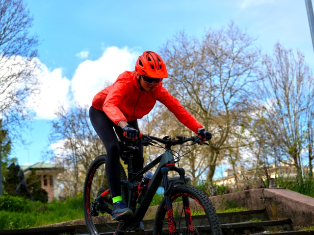 Mountainbikerin beim Fahrtechniktraining. Sie fährt über Stufen.