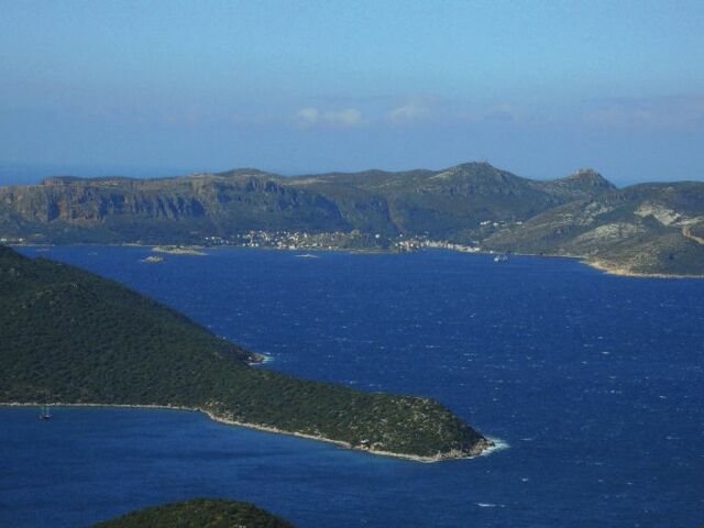 Ausblick auf das Meer mit den bewaldeten Bergen im Hintergrund bei Sonnenschein in Lykien.