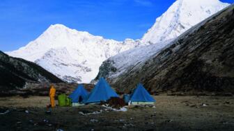 Zelttrekking in Bhutan mit schneebedeckten Gipfeln im Hintergrund
