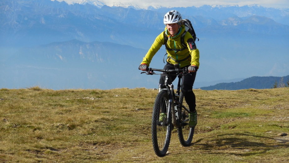 Eine Moutainbikerin auf der Tour auf einer Hochebene während der Tour an den Gardasee.