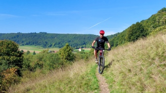 Ein Mountainbiker auf ein Singletrail im Altmühltal.