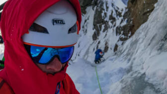 Nahaufnahme eines Eiskletterers in einer Nordwand