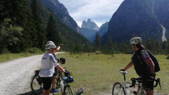 Ein Gruppe an Crossbiker/Trekkingradbiker, die auf einer Forststraße stehen. Im Hintergrund sind die Berge.