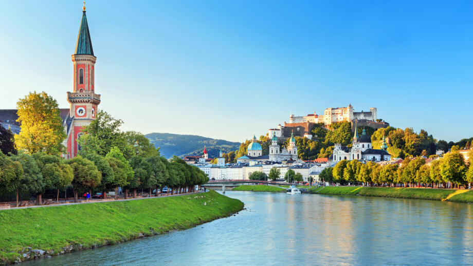 Blick auf Salzburg und die Salzach. Am Flussrand sind Häuser.