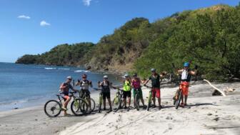 Eine MTB-Gruppe in Costa Rica am Strand. Die Sonne scheint.