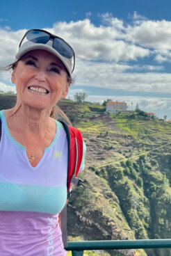 Bergwanderführerin Ingrid Schmidt lächelt uns vor traumhafter Kulisse entgegen