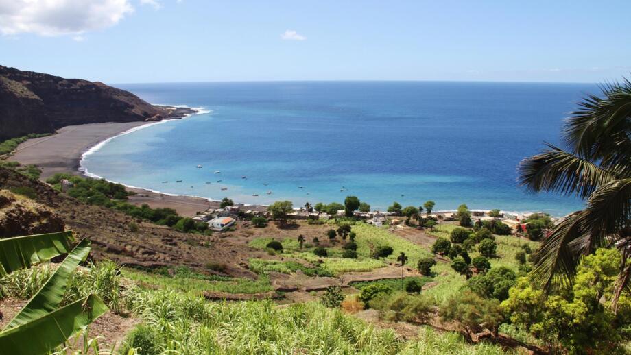 Eine Bucht im Atlantik mit schwarzem Lavasand und begrünten Hängen