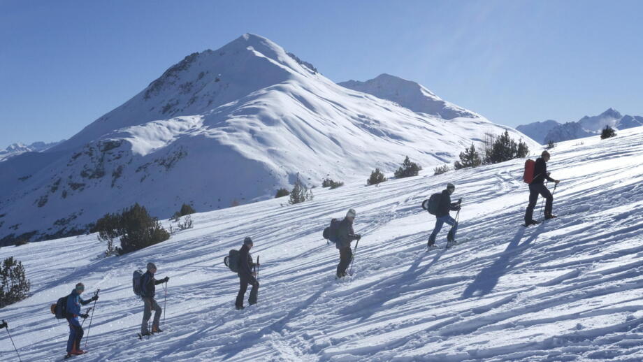 Gruppe im Aufstieg im Winterlandschaft mit Sonne und blauem Himmel