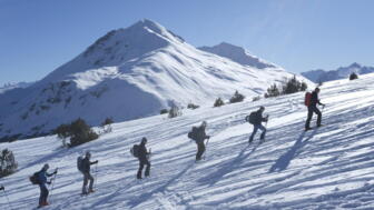 Gruppe im Aufstieg im Winterlandschaft mit Sonne und blauem Himmel
