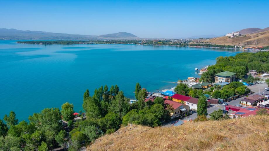 Sevansee in Armenien mit blauem Wasserund Behausungen am Ufer