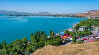 Sevansee in Armenien mit blauem Wasserund Behausungen am Ufer