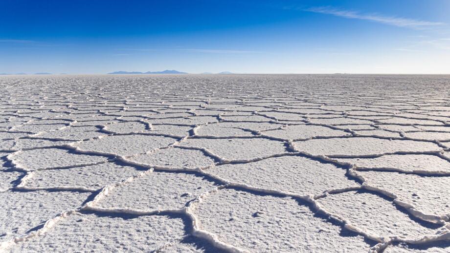 Blick über den endlosen Salzsee Salar de Uyuni mit weißen Oberflächenstrukturen in Bolivien