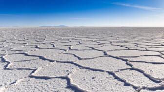 Blick über den endlosen Salzsee Salar de Uyuni mit weißen Oberflächenstrukturen in Bolivien