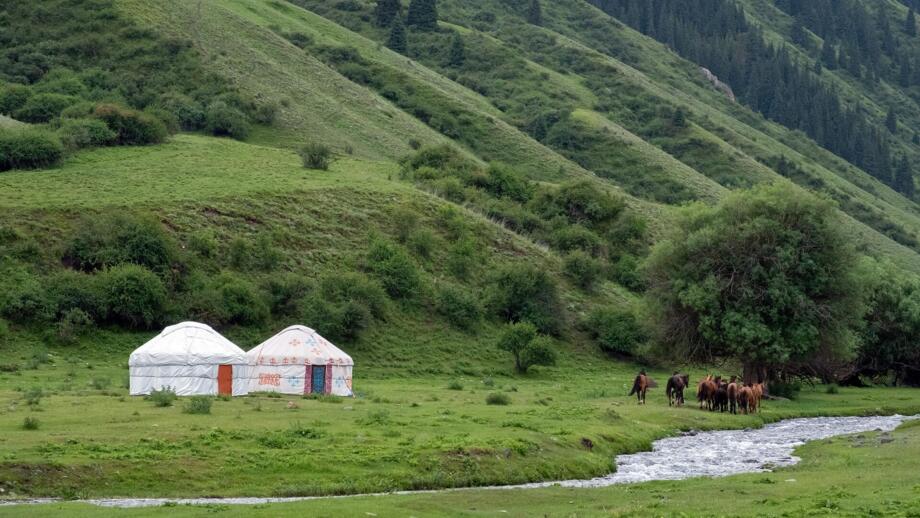 Zwei Nomadentelte, Pferde und Fluss in der grünen Landschaft des Tienshan
