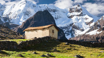 Bauerngehöft mit steinmauern vor Gletscer in der Cordillera Vilcanota