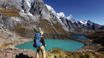 Wanderer vor Bergseen und mächtigen Bergen in der Cordillera Huayhuash