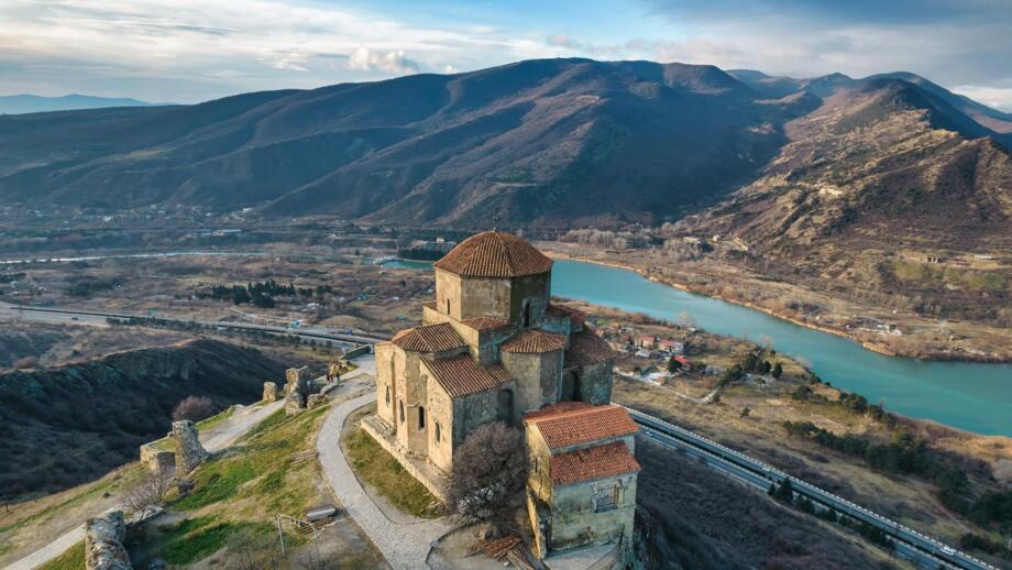 Kloster Jvari iin Georgien mit Sicht auf Fluss und braunes Hütelland