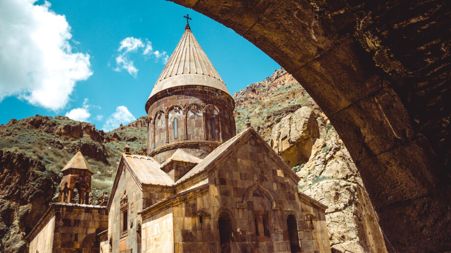 Kloster Geghard mit Kreuzkuppelkirche in einem felsigen Tal Armenies