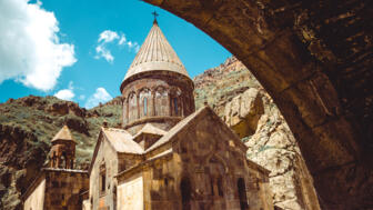 Kloster Geghard mit Kreuzkuppelkirche in einem felsigen Tal Armenies